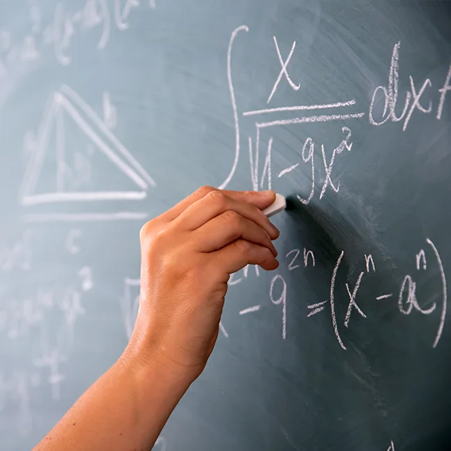 Hand schreibt mathematische Formeln auf Tafel